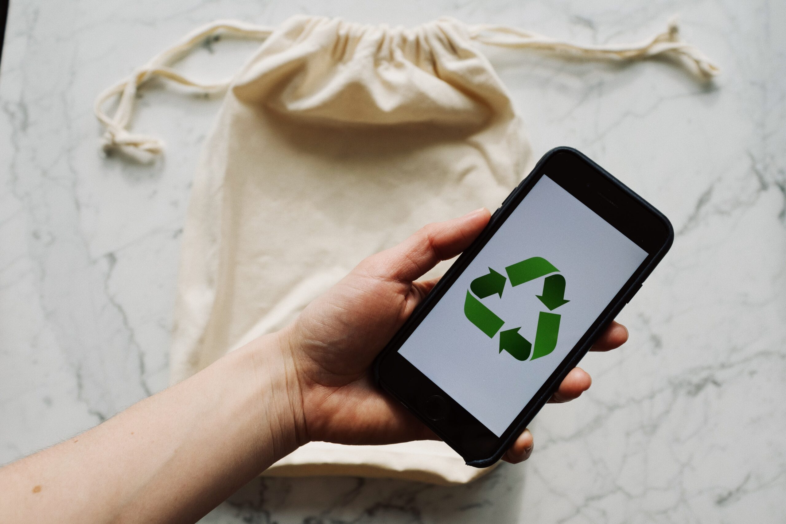 Free Faceless person showing recycle symbol on mobile phone screen Stock Photo